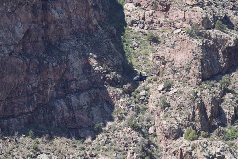 Aerial view of helicopter banking through Royal Gorge canyon with dramatic red granite walls
