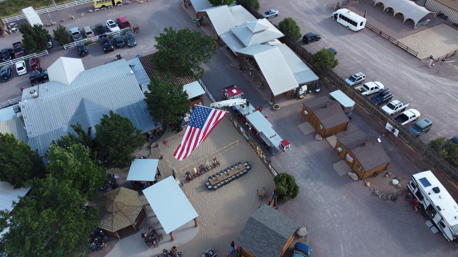 Aerial drone view of Canon City July 4th celebration with giant American flag ceremony, community gathering at WWBG venue complex